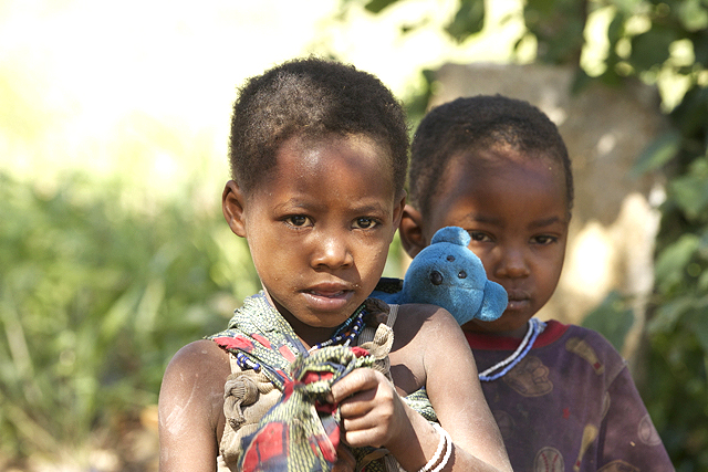 Hadzabe Child with "her baby" on her back.